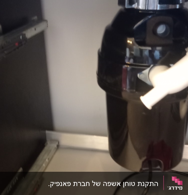 מתקן טוחן אשפה מתחת לכיור במטבח